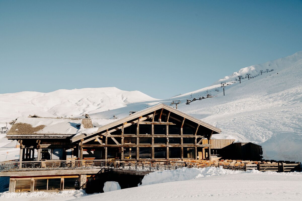 A snow covered building with a ski lift in the background