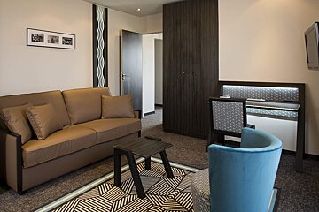 A living room with a brown couch and a blue chair