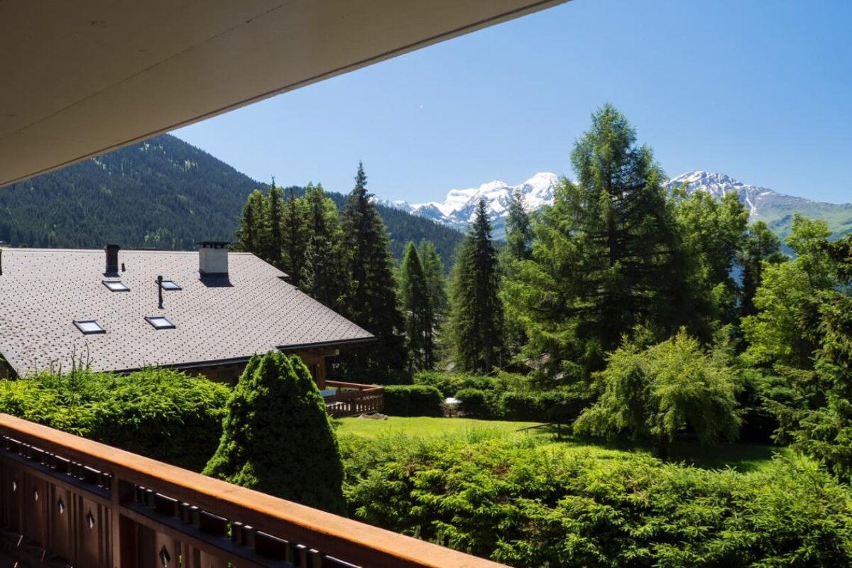 A balcony with a view of mountains and trees