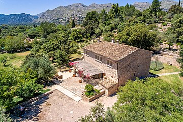 An aerial view of a house with mountains in the background
