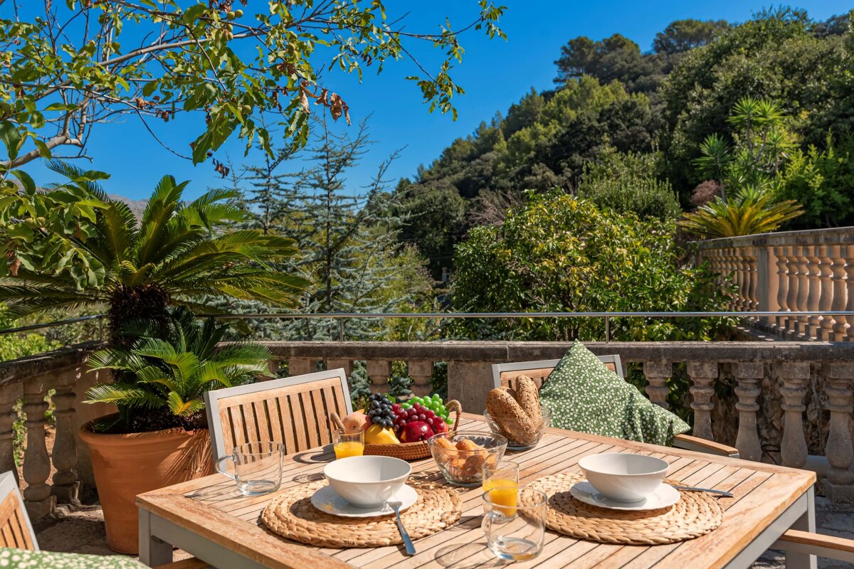 A wooden table with a bowl of fruit on it