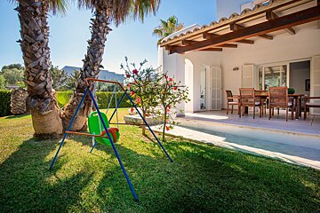 A swing set in the backyard of a house