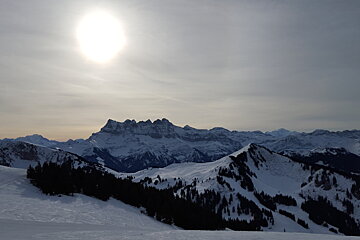 The sun is shining brightly over the snowy mountains