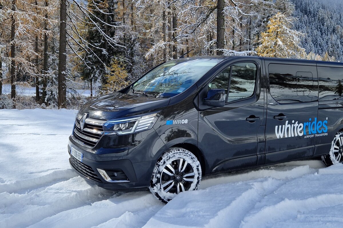 A white rides van is parked in the snow