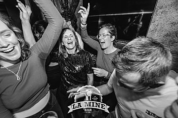 A group of people are dancing at la mine bar