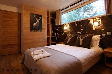 a double bed in a room with stag head pillows and painting