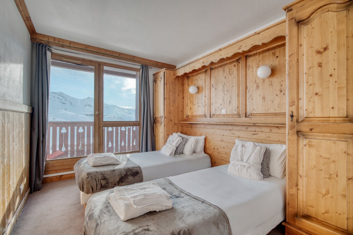 A bedroom with two twin beds and a large window