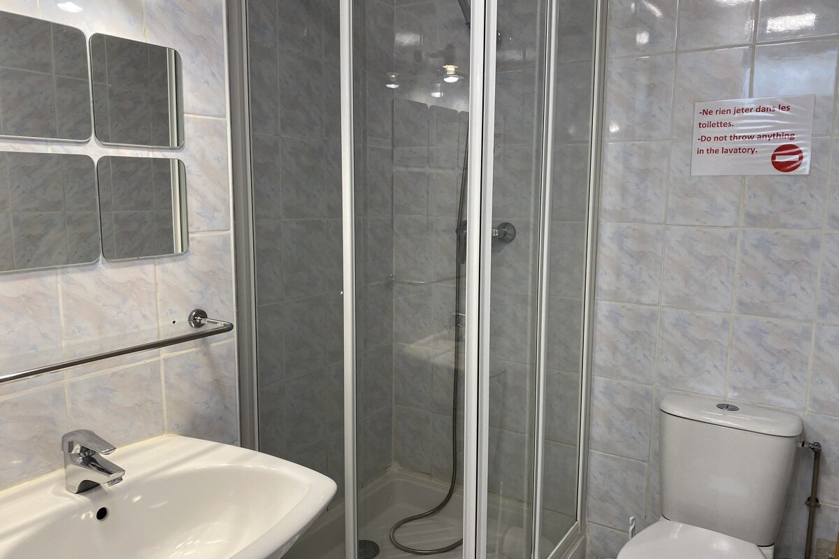 A bathroom with a sign on the wall that says 