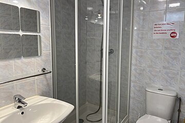 A bathroom with a sign on the wall that says 