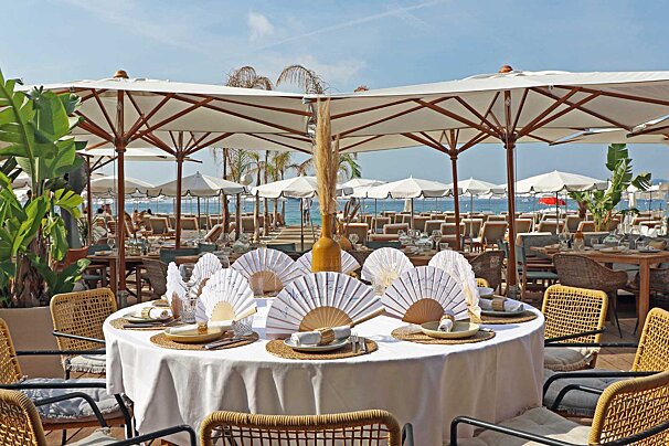 A table with a white table cloth and fans on it