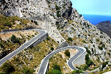 A motorcycle is riding down a winding mountain road