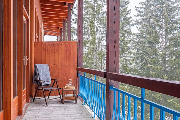 A balcony with a blue railing and a chair