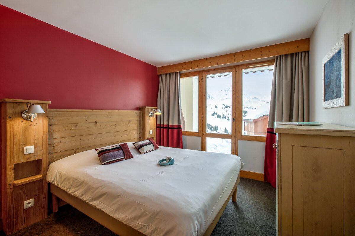A bedroom with a large bed and a window