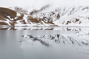 Photo of a part frozen lake in Chamonix and reflections by Thomas Lebas