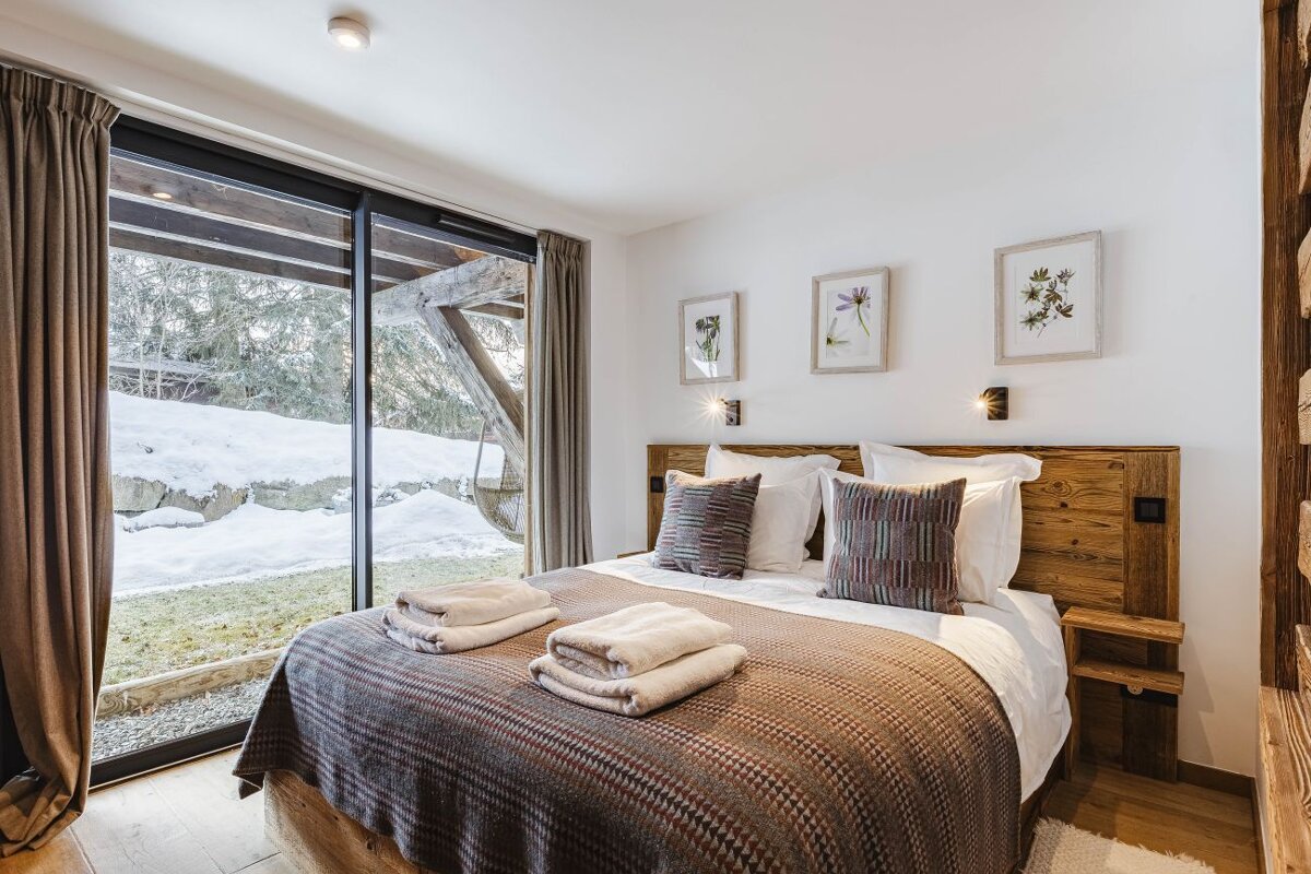 A bedroom with a large bed and a sliding glass door