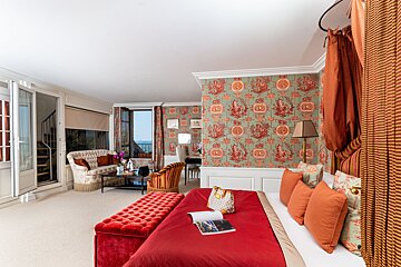 A bedroom with a red bed and a book on it