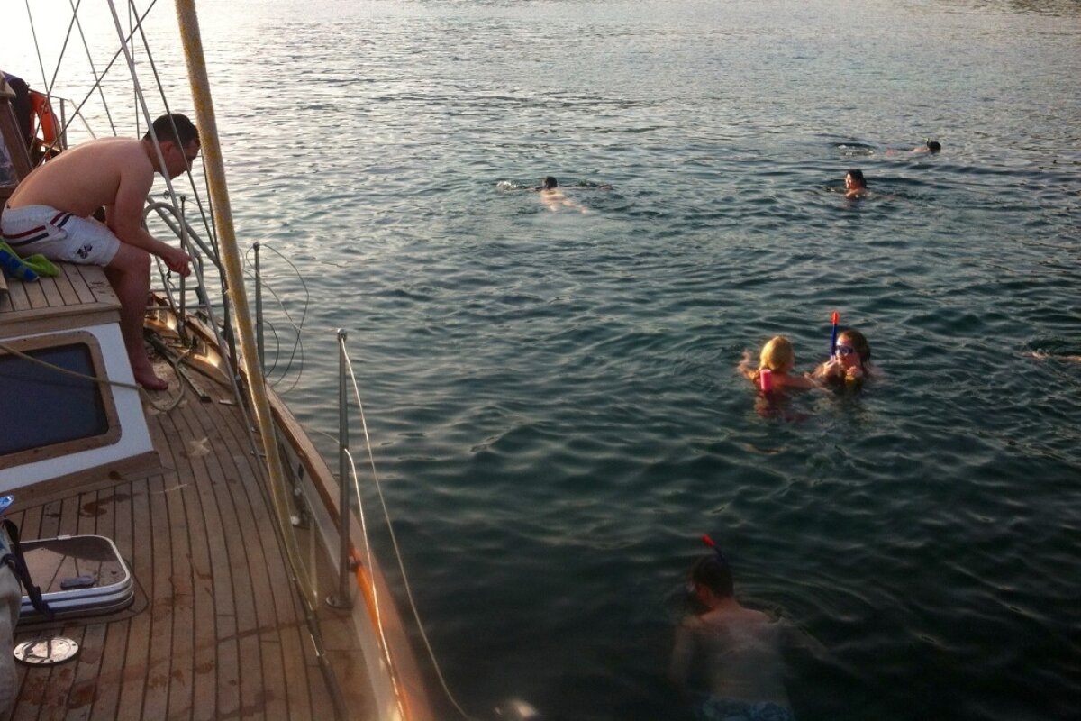 people snorkelling by the side of a boat in mallorca
