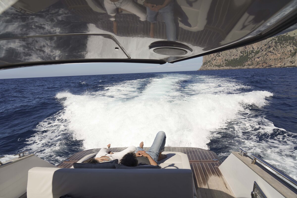 A couple laying on the back of a boat in the ocean