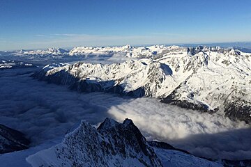 looking down over clouds in the valley