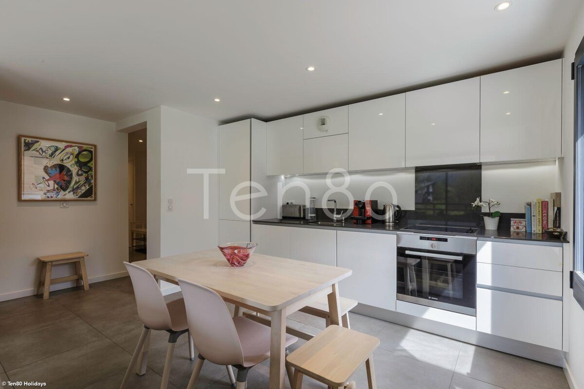 A kitchen with white cabinets and a sign that says ten80