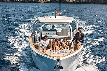 A group of people are sitting on a boat with the number 604653 on the front