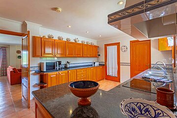 A kitchen with wooden cabinets and a black counter top