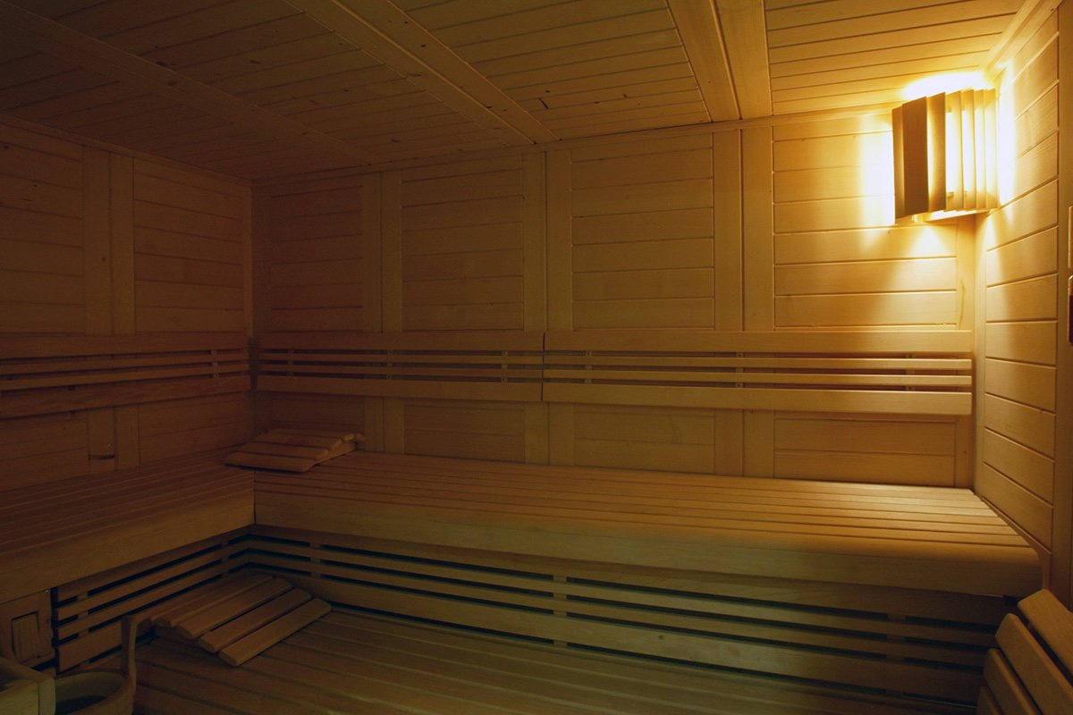 A wooden sauna with a light on the wall
