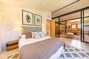 A bedroom with a sliding glass door leading to a bathroom