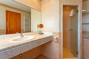 A bathroom with a sink and a walk in shower