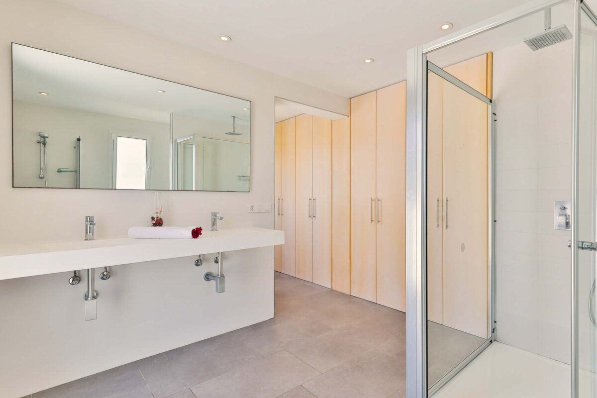 A bathroom with two sinks and a walk in shower