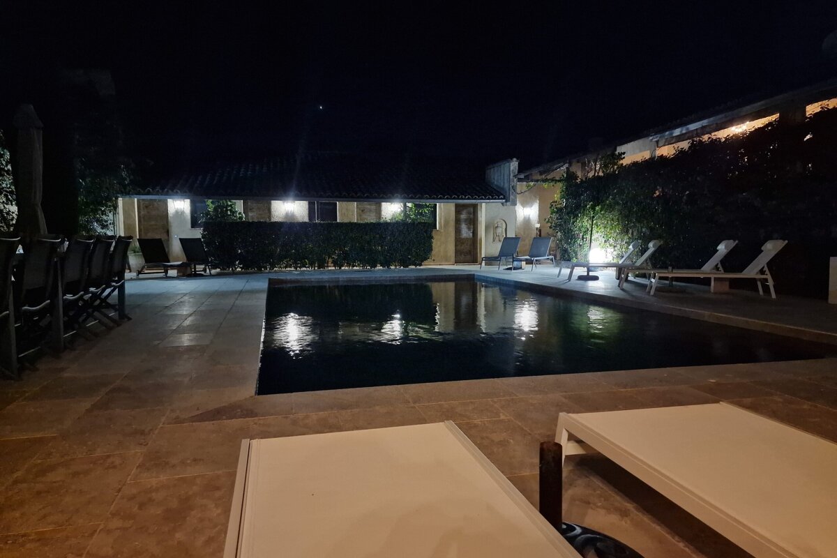 A large swimming pool is lit up at night