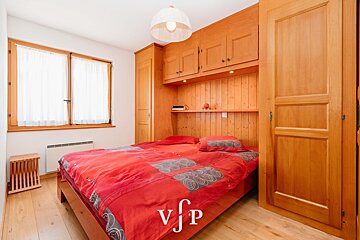 A bedroom with a red bed and a sign that says vjp