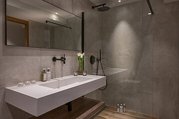 A bathroom with a large sink and a walk in shower