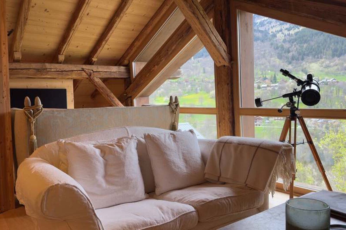 A living room with a couch and a telescope