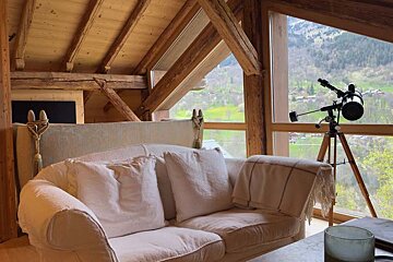 A living room with a couch and a telescope