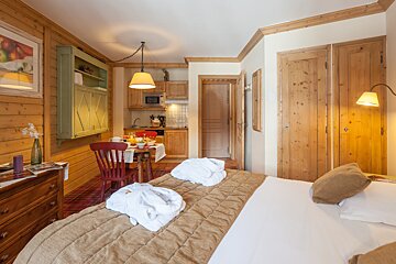 A bedroom with a bed and a table and chairs