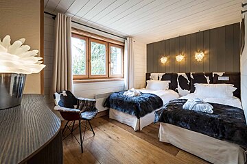 A bedroom with two beds and a cow print headboard