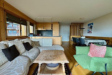 A living room with a couch and a green chair