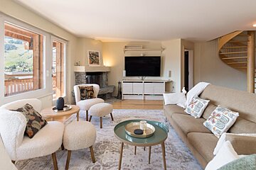A living room with a couch and chairs and a flat screen tv