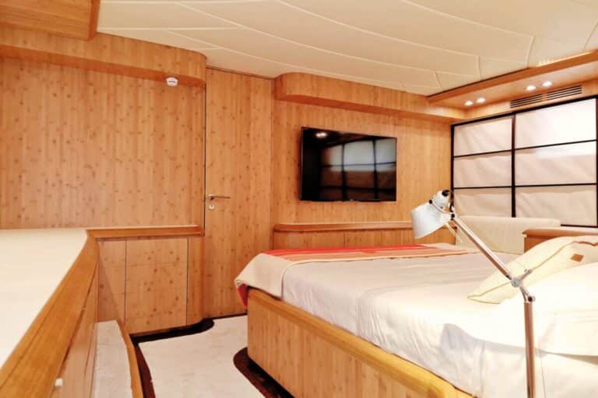 A bedroom with a large bed and a flat screen tv on the wall