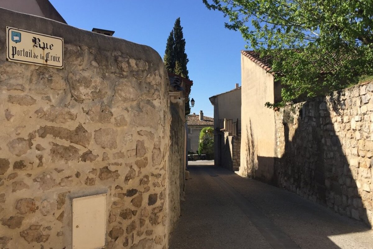 a stone wall and a street in provence