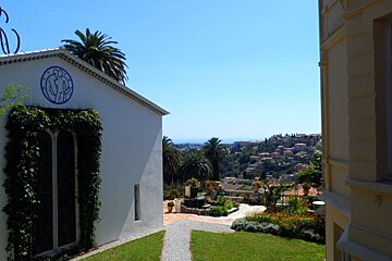 a white painted stone building with a path in the grass