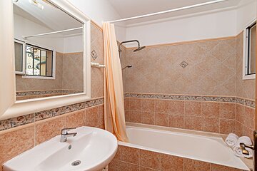 A bathroom with a sink a bathtub and a mirror