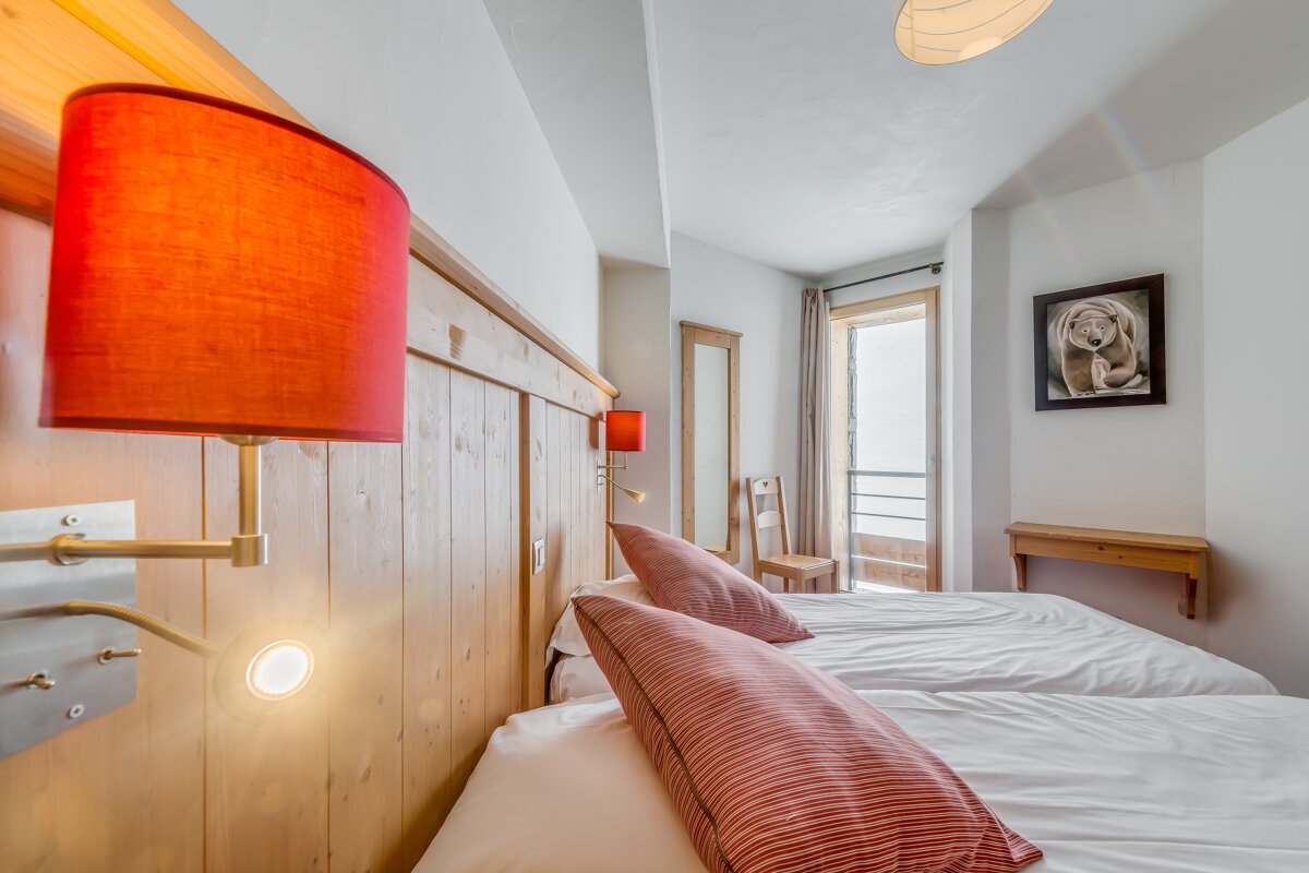 A bedroom with two beds and a picture of a bear on the wall