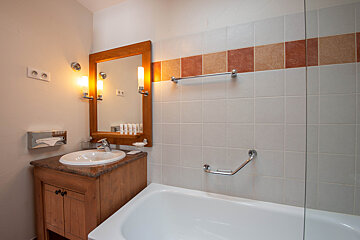 A bathroom with a sink a mirror and a bathtub