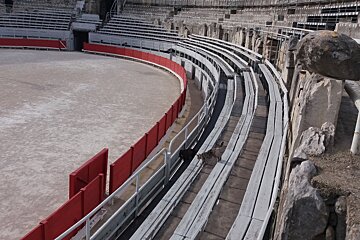 An empty stadium with a red fence and white seats