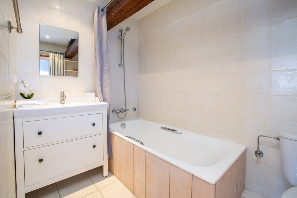 A bathroom with a bathtub a sink and a mirror