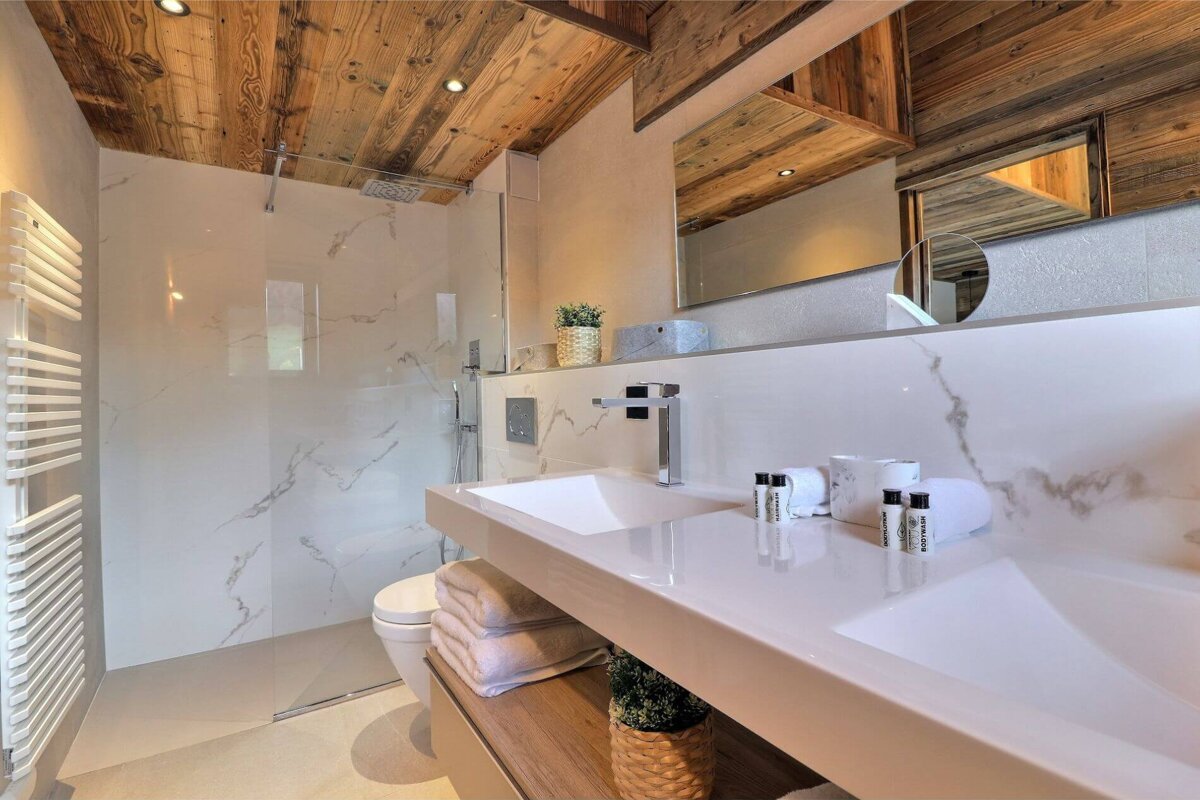 A bathroom with a walk in shower and a sink