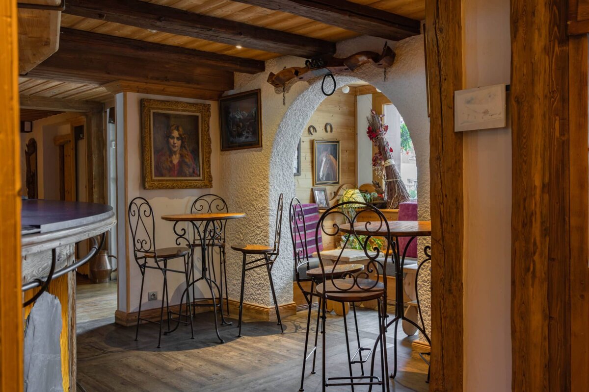 A room with tables and chairs and a painting on the wall