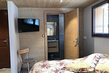 A bedroom with a bed and a flat screen tv